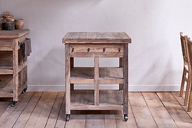 The nkuku Tivu Reclaimed Wood Butchers Block - Natural boasts a rustic look with four shelves, a drawer, and caster wheels—ideal for stylish, functional farmhouse kitchen storage.