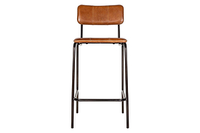 The nkuku Ukari Counter Chair in Aged Tan features tan buffalo leather upholstery with visible stitching, a padded seat and backrest, and a sleek black metal frame with four legs and footrest rail. Photographed front-on against a white background.