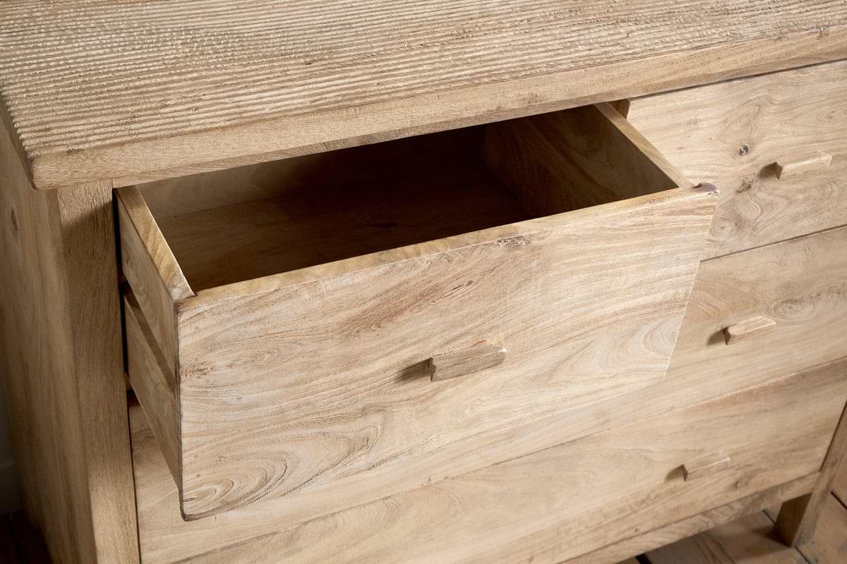 The nkuku Vivan Grooved Chest of Drawers in natural features simple rectangular handles and visible wood grain, with a partially open drawer—an elegant and practical storage solution for any bedroom.