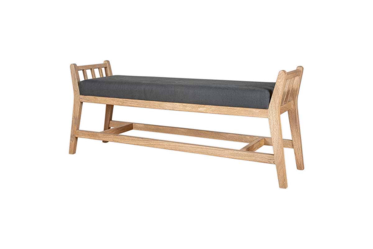 The nkuku Avanthi Upholstered Sleigh Bench in Charcoal features a carved wooden frame with angled legs, open slat sides, and a rectangular dark gray cushioned seat, shown against a white background.