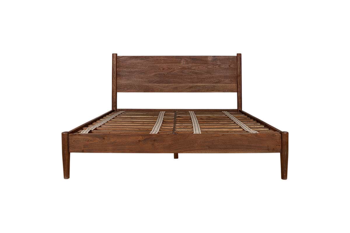 The nkuku Anbu Acacia Bed in Washed Walnut features a sculptural, mid-century modern frame with a tall headboard and slatted base, shown from the front against a white background.