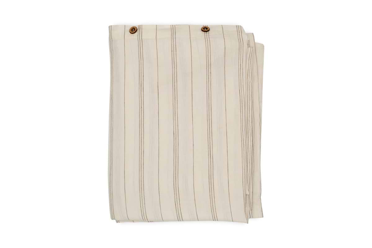A neatly folded pair of beige pants with vertical thin brown stripes and two brown buttons at the waistband, echoing the natural sage green tones of the nkuku Anta Hemp & Cotton Duvet Cover.