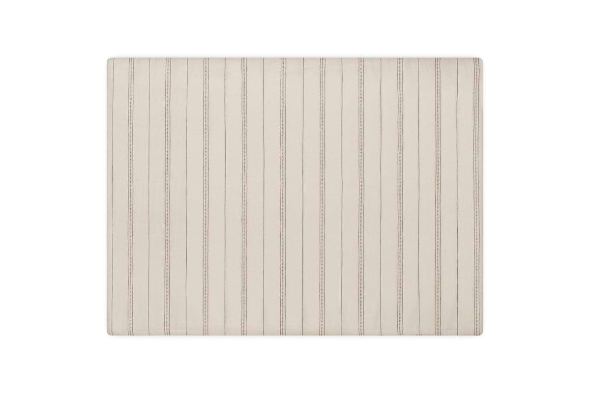 A square, light beige rug with thin vertical dark stripes pairs beautifully with nkuku’s Anta Hemp & Cotton Housewife Pillowcases in Sage Green for a calming, natural look on a plain white background.