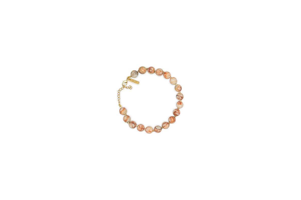 The nkuku Cerita Bracelet - Rhodochrosite showcases round marbled pink and beige stones, strung together with a gold chain extender and clasp. Presented on a plain white background, it’s a versatile accessory.
