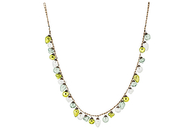 The nkuku Ekiti Bauble Garland - Mixed Green & Clear features a delicate brown chain with evenly spaced recycled glass beads in teardrop shapes of green, white, and yellow, forming a playful U-shape necklace.