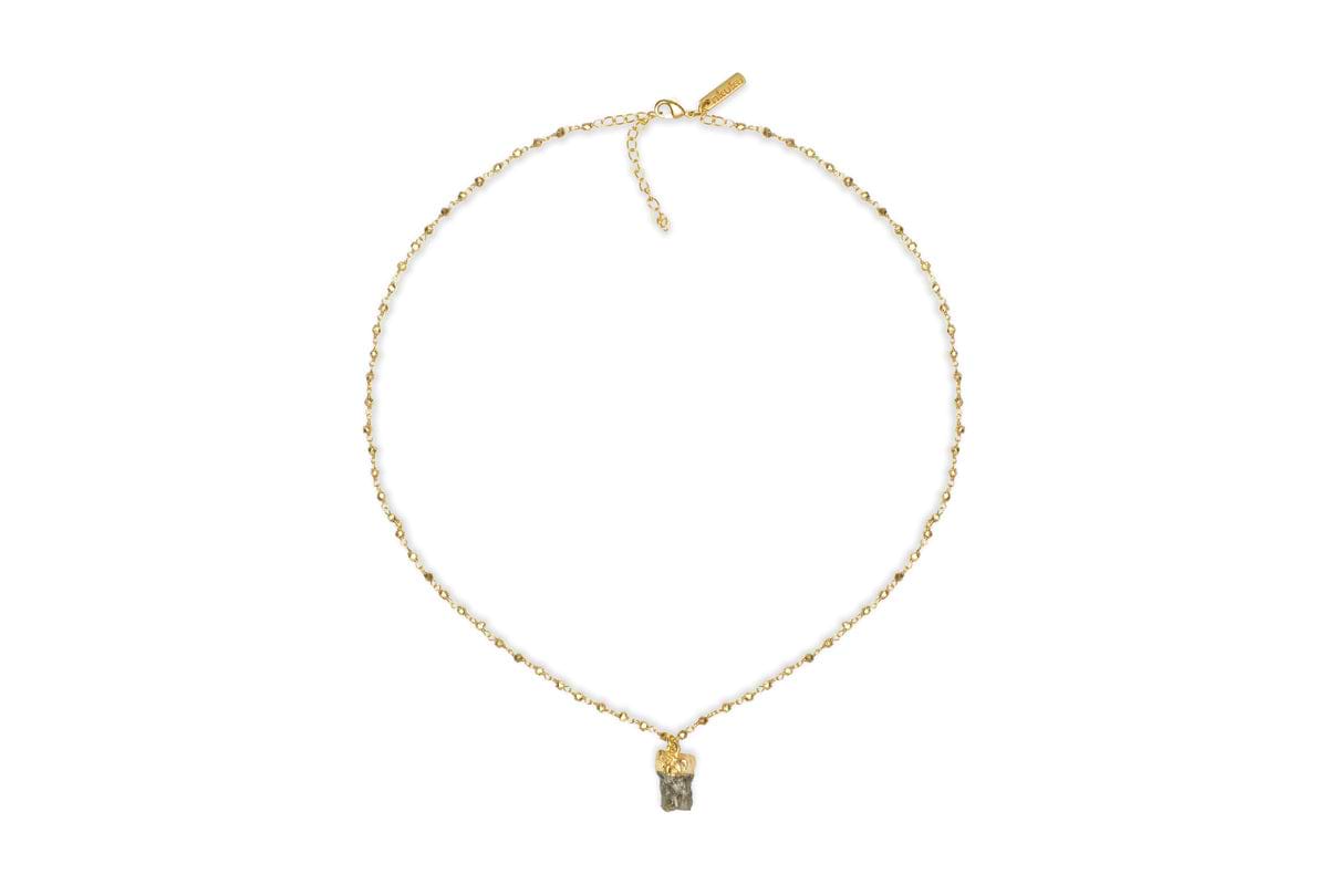 The Hadari Labradorite Necklace by nkuku features an irregular gray labradorite stone pendant on a delicate gold chain, showcased against a white background.