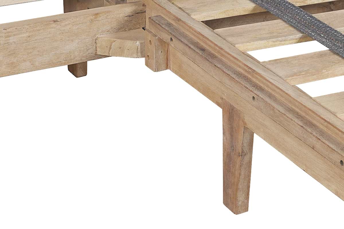 Close-up of the Iya Reclaimed Wood Bed - Natural by nkuku, showing its rustic corner with slats and angled legs, and highlighting the natural wood grain and craftsmanship against a white background.