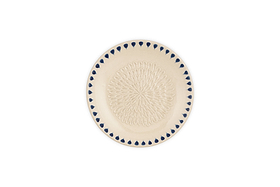 The nkuku Indigo Drop Garlic Grater in cream and indigo features an intricate raised looped center pattern and a border of blue teardrop shapes, with a subtle hand-painted design from the Indigo Drop collection.