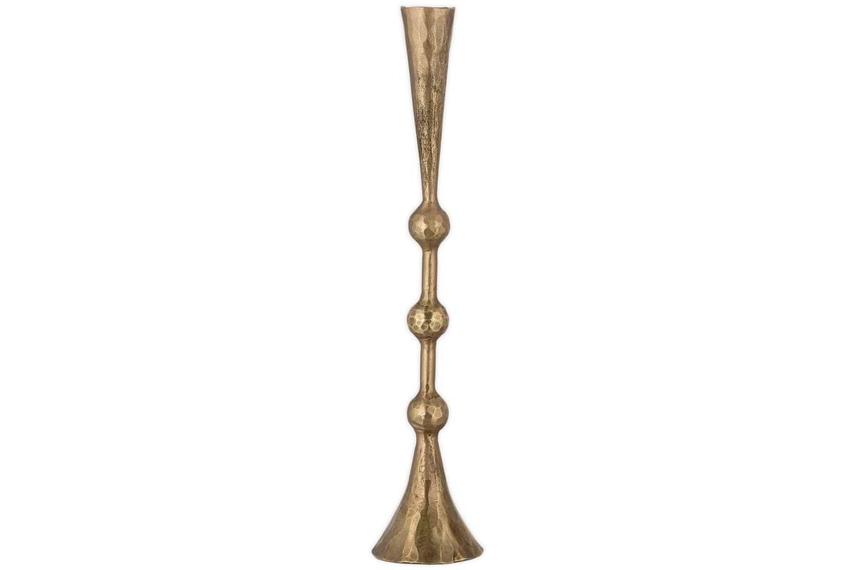 The nkuku Javanee Candle Holder in antique brass is tall and slender, with a flared base and top, showcasing sculptural elegance through two rounded, bulbous sections along its stem.