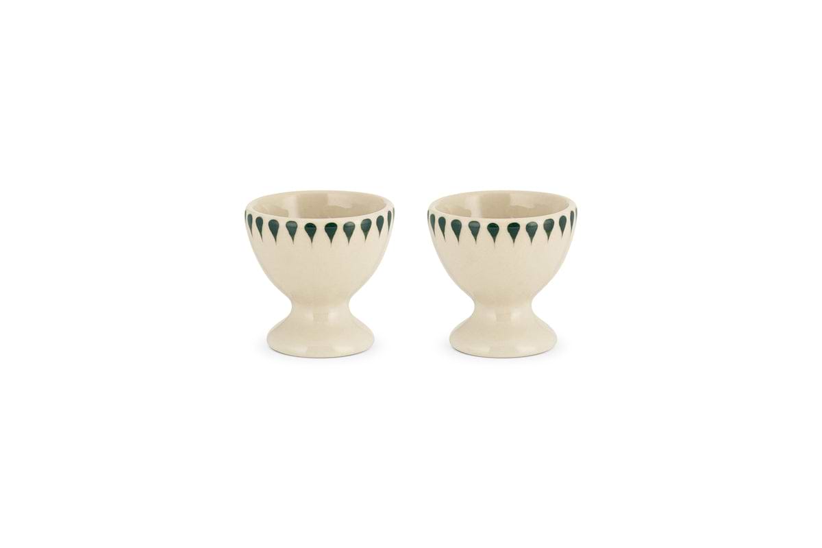 The nkuku Juniper Drop Egg Cups in cream & juniper (set of 2) feature a green drop design around the rim—perfect for brightening up your breakfast table.