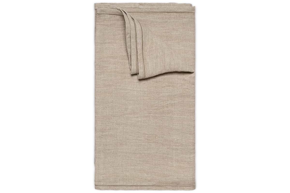 The Junto Linen Runner- Natural - Large by nkuku is displayed on a white background. Its smooth, beige linen finish and crisp edges add elegance and harmony to any table setting.