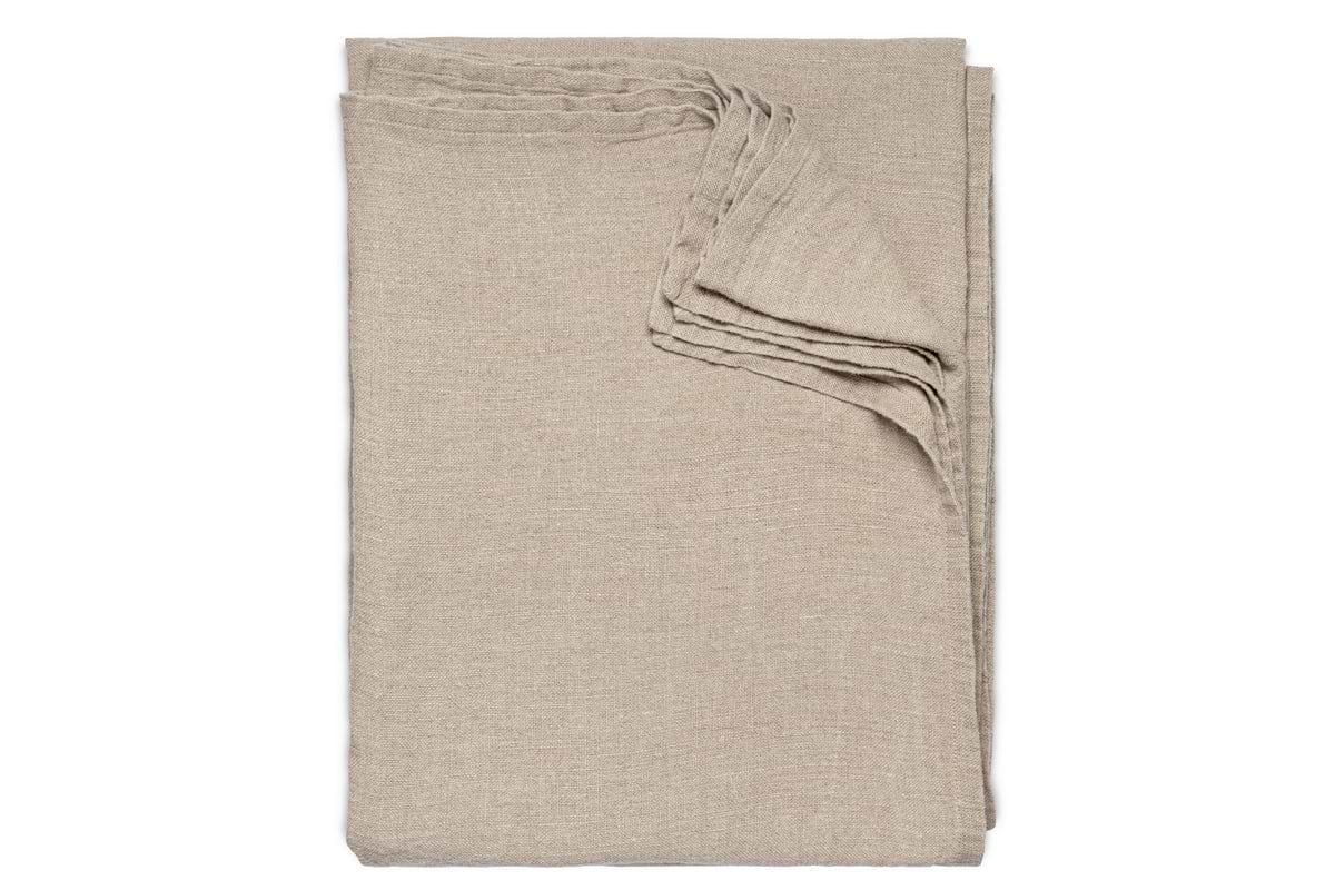 The nkuku Junto Linen Tablecloth in Natural (Large) is neatly folded and arranged on a white background.