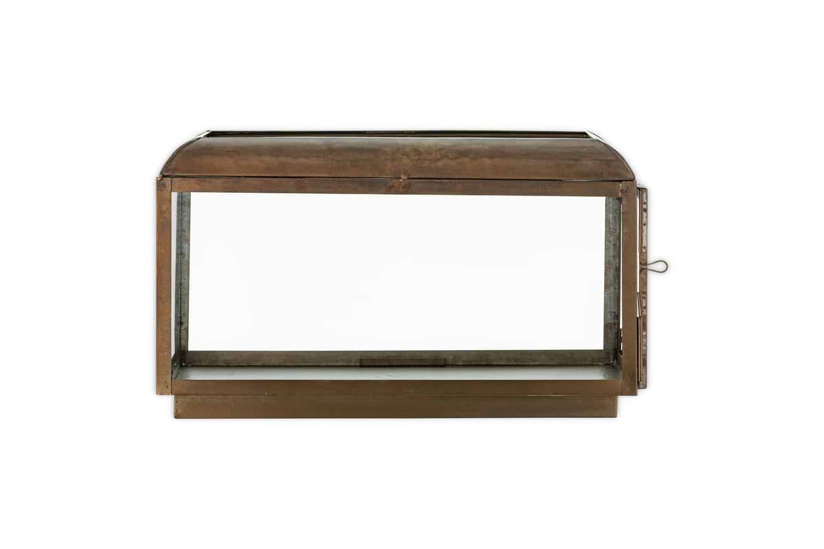 The Kiwanda Wide Lantern by nkuku features an antique brass rectangular metal and glass design with a domed top, open front, and small latch on the right side, evoking classic lantern styles. Shown against a white background.