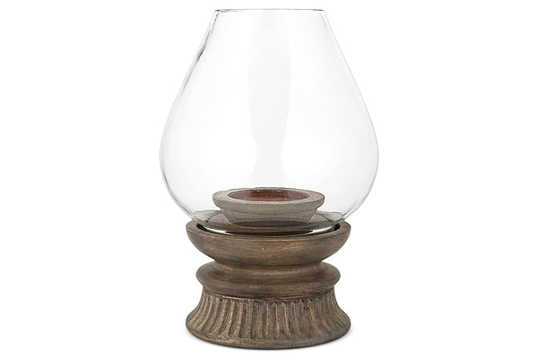 The nkuku Kawani Mango Wood Lantern in Dark Ash features a glass vase on a mango wood stand, ideal for displaying rustic pillar candles.