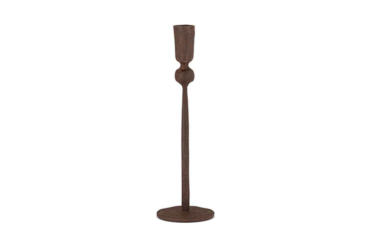 The Mawindi Candle Holder - Rust by nkuku is a tall, slender iron candlestick with a round base and minimalist design in dark brown, perfect for adding an earthy touch to your decor.