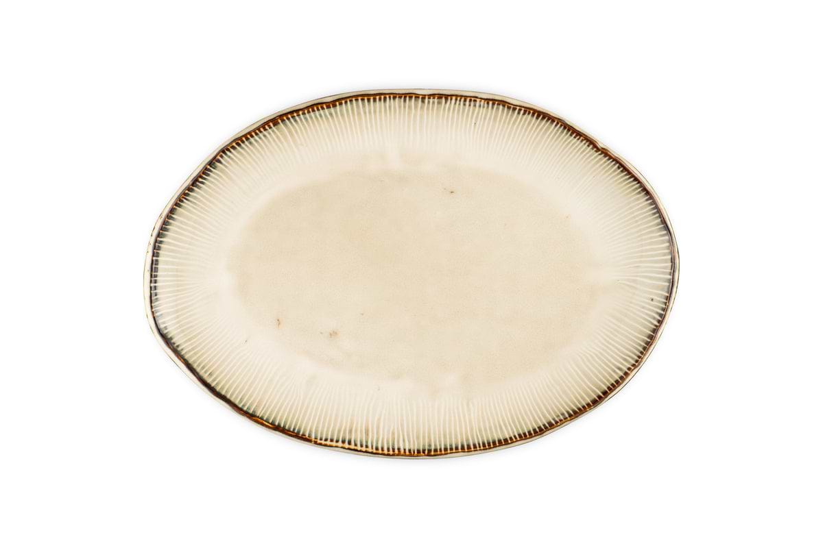 The nkuku Malia Large Oval Platter - Cream features an organic oval shape, cream center, subtle textured lines radiating outward, and a slightly darker irregular rim. The empty ceramic platter is set against a white background.