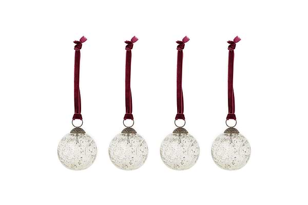 The nkuku Nishan Pinched Baubles - Clear (Set of 4) feature round, recycled glass ornaments with silver caps and burgundy velvet bows, offering a speckled, vintage look that’s perfect for festive decor.
