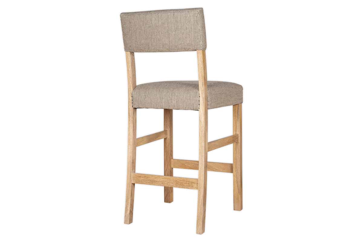 The nkuku Nadeeka Linen Upholstered Counter Chair in Soft Grey features cushioned linen seat and backrest, straight wooden legs, and a footrest—shown angled on a white background. Ideal for your kitchen island.