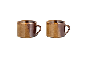 The nkuku Naav Mugs - Mustard (Large, Set of 2) are displayed side by side on a white background, each featuring a handle and unique glaze with subtle color variations.