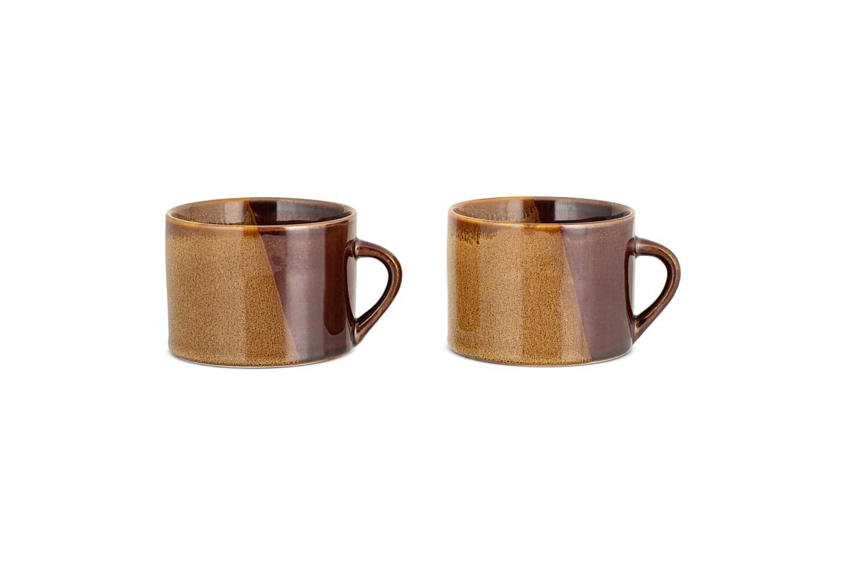 The nkuku Naav Mugs - Mustard (Large, Set of 2) are displayed side by side on a white background, each featuring a handle and unique glaze with subtle color variations.