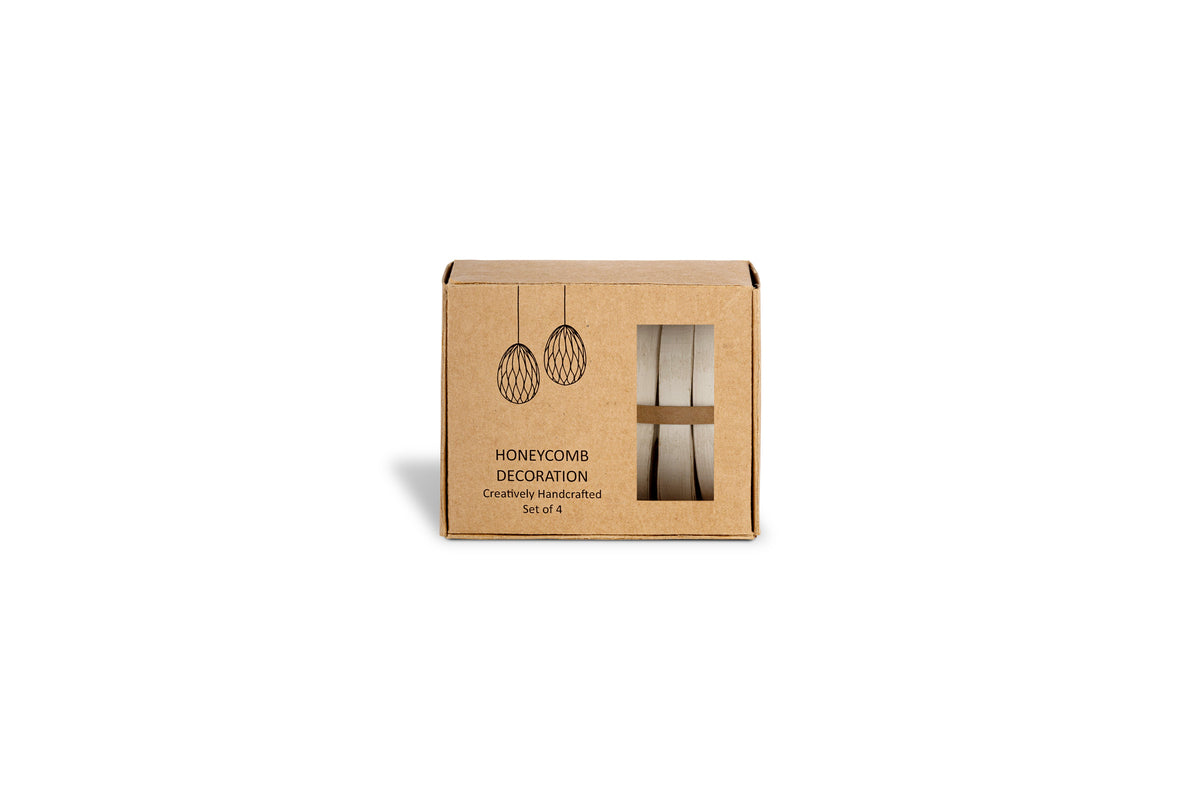 A small brown box labeled "Piani Hanging Paper Decoration - Moss Green - Set of 4" by nkuku, with illustrations of paper decorations. The window shows two rolled green honeycomb eggs inside. White background.