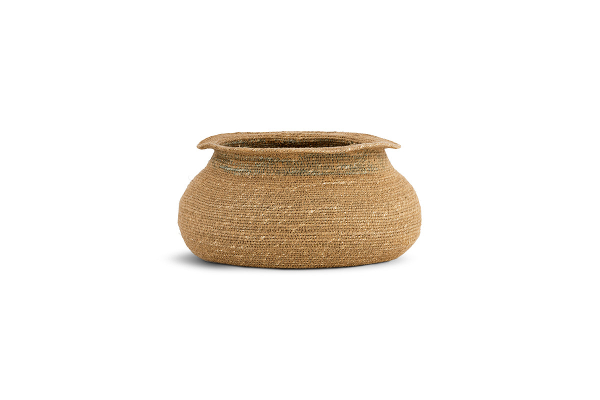 The nkuku Rana Short Basket - Natural & Moss features a wide, round woven design with a slightly tapered opening and flared rim. Crafted from light brown seagrass fibers, it brings textured charm to any natural home decor.