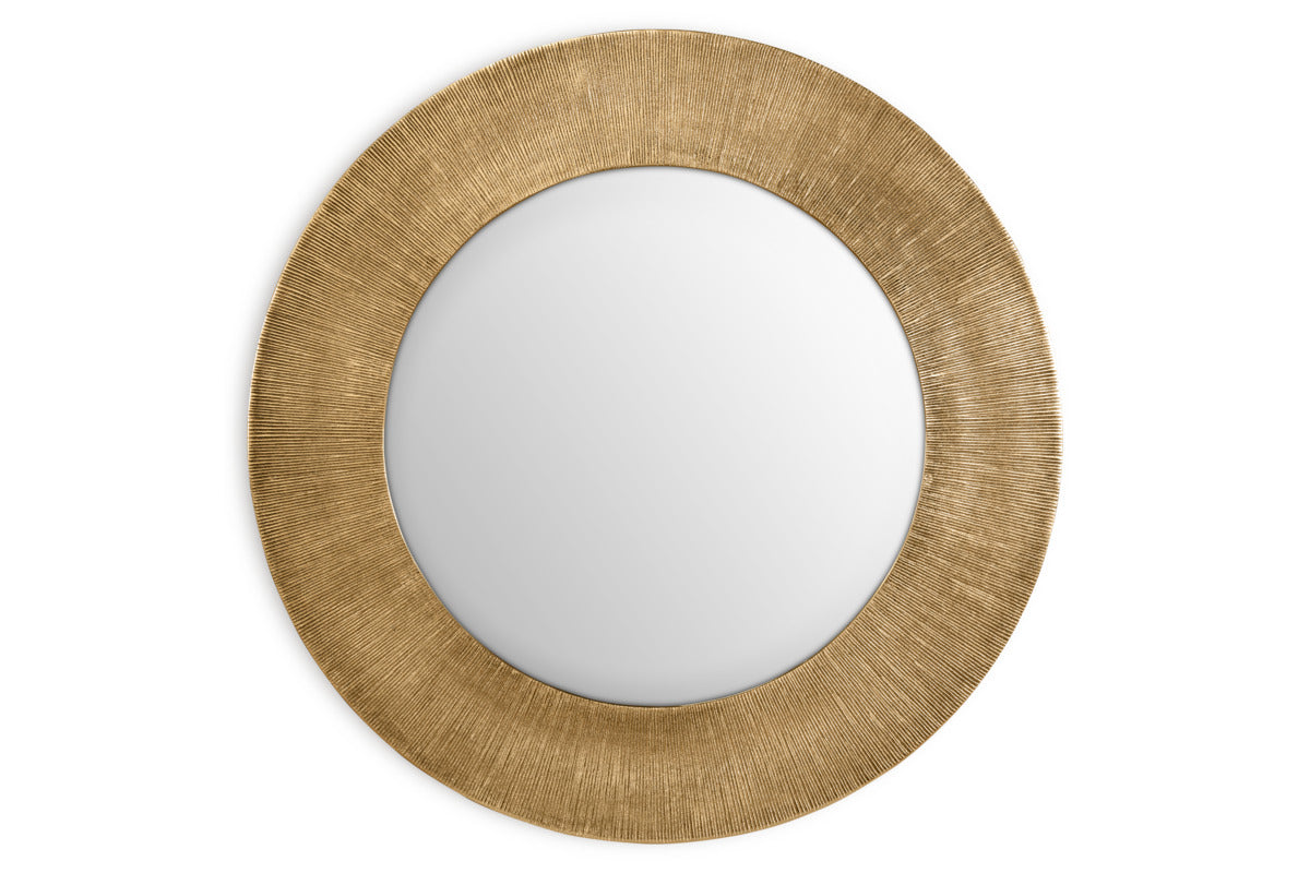 The nkuku Moto Round Mirror - Antique Brass features a wide, textured gold frame with fine lines for a subtle sunburst effect. Its minimalist design and antique brass finish add elegance and style to any space.