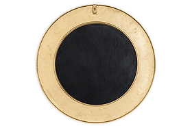 The Moto Round Mirror by nkuku features an antique brass finish and a wide border, with a small hanging hook at the top. This minimalist mirror rests against a plain white background, perfect for elegant decor.