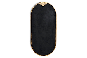The nkuku Mbwa Oval Mirror in Antique Brass has a decorative gold frame and an elongated black oval center. It features a top triangular notch with hanging hole, and is shown against a white background.