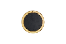 The Putali Etched Mirror - Antique Brass by nkuku is a sculptural wall mirror with a wide gold-toned rim adorned with subtle engravings, a rectangular top detail, and a solid black center, shown from above on a white background.