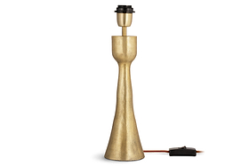 The Marpha Antique Brass Table Lamp by nkuku features a tall, slender textured gold base with a flared bottom. Its exposed black bulb socket, orange electrical cord, and black switch are visible on the right side. No lampshade included.