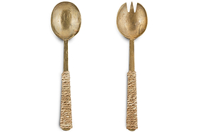 The Abani Salad Servers by nkuku feature a spoon and two-tined fork handcrafted from antique brass, each with a textured woven seagrass handle for a rustic look. Displayed on a white background.