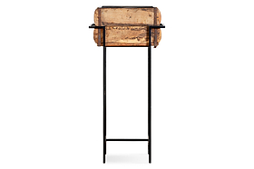 The nkuku Amazzi Indoor Planter Stand - Natural & Black features thin black metal legs and a crossbar, supporting a rustic reclaimed wooden planter box with a weathered finish, shown front-facing against a plain white background.