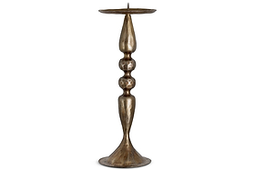 The Ayo Pillar Candle Holder - Brass by nkuku features a tall, slender silhouette with a wide, flared base, an elegantly hammered aged-brass finish, and a central spike on its flat circular top to securely hold your candle. Its stem is accented by three rounded bulges, making this metallic piece a striking example of sculptural decor.