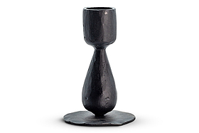 The Suba Candle Holder - Black by nkuku is crafted from blackened iron and features a textured, handmade appearance. Its design includes a rounded base, a slim, teardrop-shaped stem, and a cylindrical cup at the top for holding a candle. Photographed on a white background, this elegant piece adds timeless sophistication to any table setting.