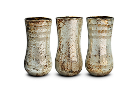 Three Rumi Recycled Glass Mini Vases by nkuku stand side by side against a white background, forming an exquisite decorative set. Each mini vase features a slightly flared rim and a rounded, narrow base, crafted from recycled glass. Their surfaces display a mottled, rustic texture with silvery and brownish hues, showcasing the elegant Silver Rust finish that gives them a vintage, aged look.
