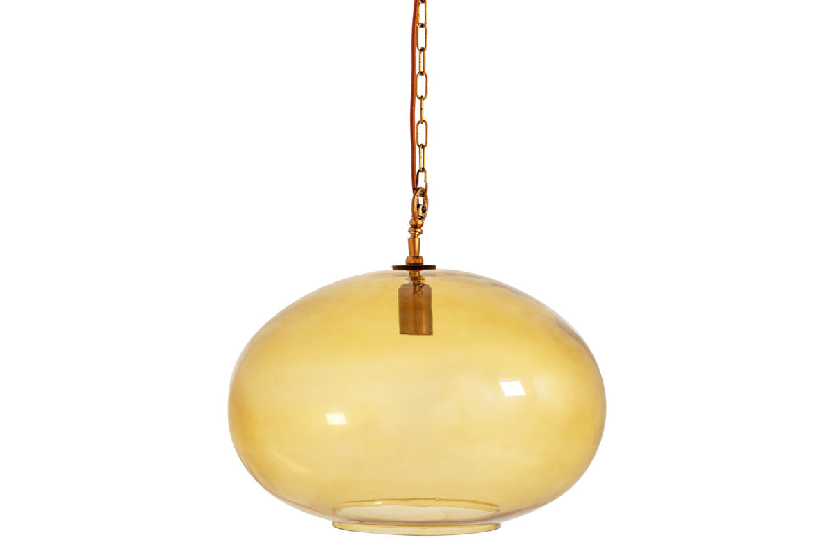 The Otoro Recycled Glass Pendant – Honey – Large Round by nkuku hangs from a gold chain with elegant brass fittings. Its smooth, glossy amber globe softly reflects the light, while the simple and minimalistic fixture inside remains visible. The light is off, set against a plain white background.
