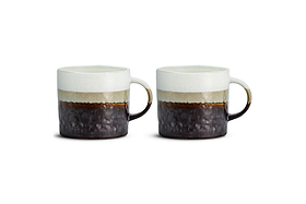 Two Chaay Mug - Small mugs from nkuku sit side by side on a white background. Each mug showcases a striking colour block design with a white upper half, a greenish band in the middle, and a dark, textured lower section. With rounded handles and a handmade, rustic finish, this set of two is ideal for modern kitchens or as an addition to your Chaay mug collection.