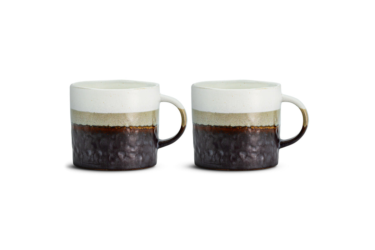 Two Chaay Mug - Small mugs from nkuku sit side by side on a white background. Each mug showcases a striking colour block design with a white upper half, a greenish band in the middle, and a dark, textured lower section. With rounded handles and a handmade, rustic finish, this set of two is ideal for modern kitchens or as an addition to your Chaay mug collection.