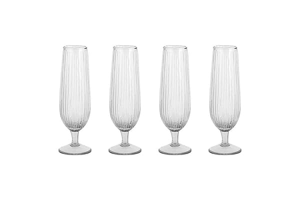 The Otuba Champagne Flute - Clear (Set of 4) by nkuku features four ribbed, recycled glass flutes arranged in a row on a white background.