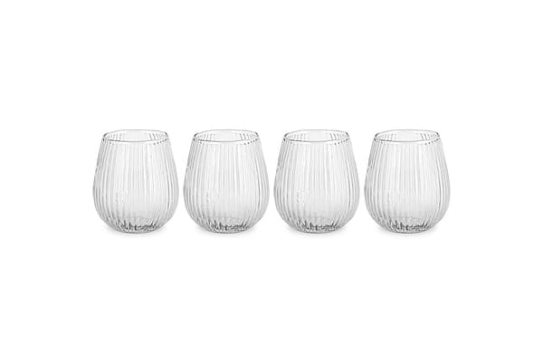 The nkuku Otuba Tumbler - Clear (Set of 4) features four ribbed, recycled glass tumblers arranged in a row on a white background, bringing elegant tableware style to any setting.