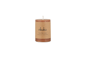 A Rustic Soy Blend Mini Pillar Candle in rust by nkuku with a textured finish and label, shown against a plain white background.