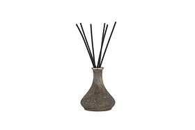 The nkuku Cedarwood & Fig Reed Diffuser features a rustic, speckled ceramic bottle with a narrow neck and black reeds, ideal for spreading a soothing cedarwood scent.