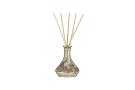 The nkuku Mandarin & Clove Reed Diffuser features a metallic, textured vase design with six light wooden reeds and fills the air with a festive spiced mandarin scent, shown against a plain white background.