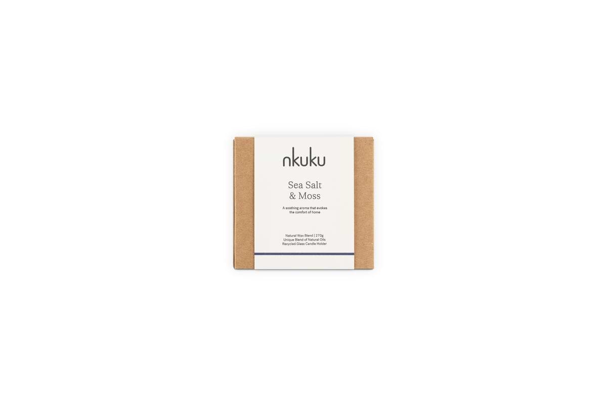 A square nkuku box with simple brown cardboard packaging features a white center label detailing the Sea Salt & Moss 1 Wick Scented Candle and its bespoke fragrance.