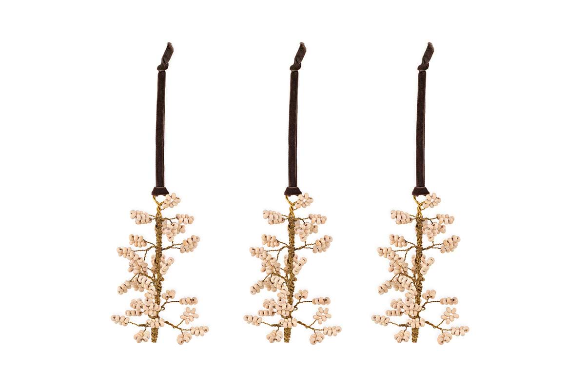 The nkuku Tanu Mango Wood Beaded Baubles – Brass & Natural (Set of 3) feature elegant branch-shaped ornaments with white beads on dark brown velvet ribbons, perfect for Christmas trees or festive table decor.