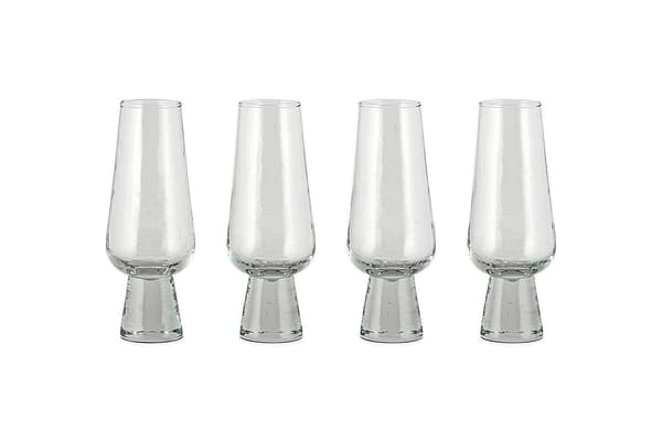 A set of four nkuku Visla Champagne Flutes in clear, hand-blown glass with wide, sturdy bases is arranged in a row on a white background.