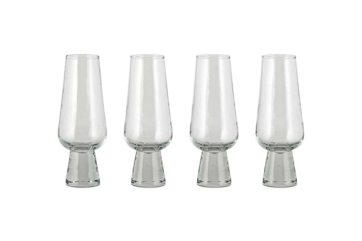 A set of four nkuku Visla Champagne Flutes in clear, hand-blown glass with wide, sturdy bases is arranged in a row on a white background.