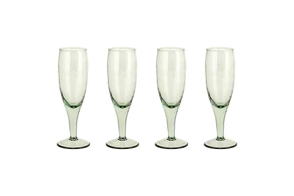 The nkuku Yala Hammered Champagne Glasses (Set of 4) in sage green feature textured, hammered glass and are shown side by side on a white background.