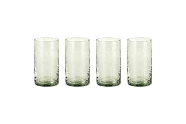 Four Yala Hammered Highball glasses in sage green by nkuku are arranged in a row on a white background. This set includes four cylindrical cocktail glasses.